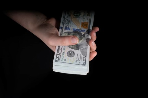 Hand holding American dollar banknotes isolated on white background