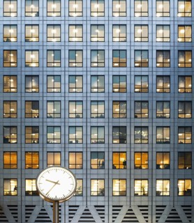 Clock and office at dusk themes of routines working late deadlines