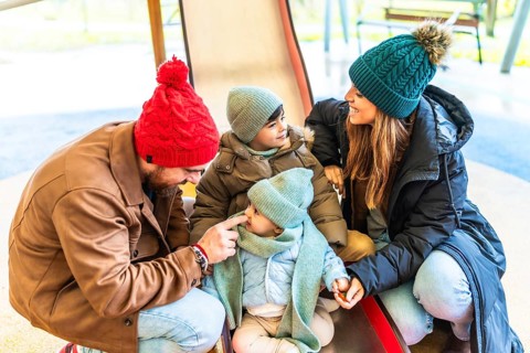 Parents and children enjoying quality time together on a slide at the playground, embracing the joy