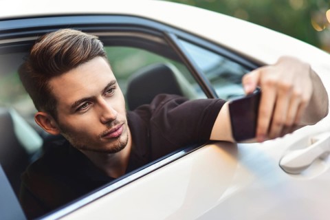 Passenger businessman use a smartphone in the back seat of the car