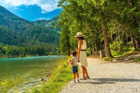 Tourists enjoying the scenic landscape of lake dobbiaco, surrounded by the majestic dolomites,