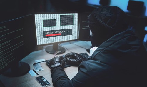 Shot from the Back to Hooded Hacker Breaking into Corporate Data Servers from His Underground
