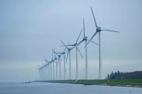 Wind turbines in a row on the coast in the mist and fog