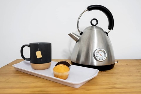 Tray with muffins and tea, electric kettle. Concept of pause, refreshment, relaxation