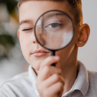 Portrait boy using magnifier class