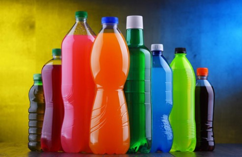 Plastic bottles of assorted carbonated soft drinks in variety of colors