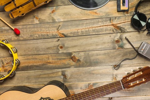 Close up guitar headphone tambourine xylophone headphone radio wooden table with space text.