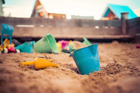 Children plastic toys in the sand box. Dirt bucket, selective focus