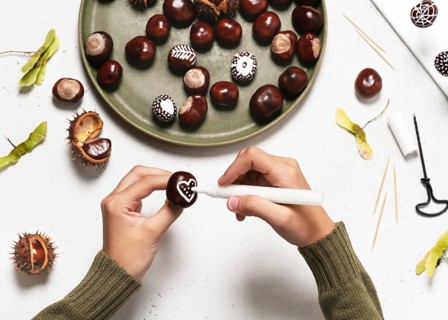 Step 3: Draw a heart on a chestnut with a white acrylic pen. Handicrafts with children. Step by