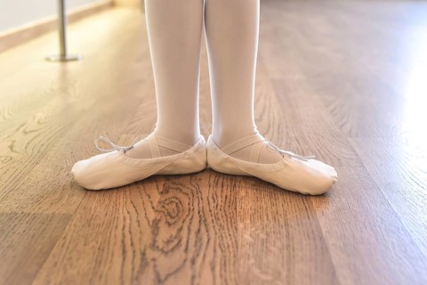 Child's legs of a girl in pointe shoes preparing for ballet classes