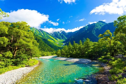 The pristine alpine water of Azusa River flowing in front of landscape view of Mount Hotaka-Dake on