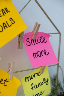 SMILE MORE self care goal on Action board new year's resolutions on colorful sticky notes. Making