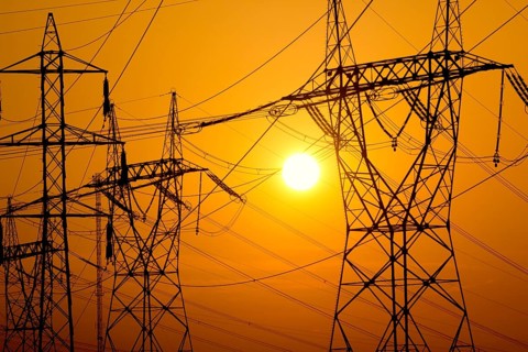 Transmission towers on sunset sky