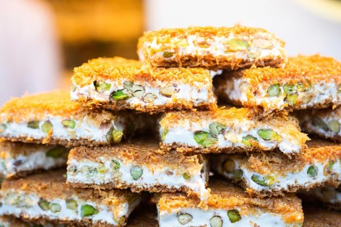 Turkish traditional dessert Kadayif baked in syrup served with nut powder