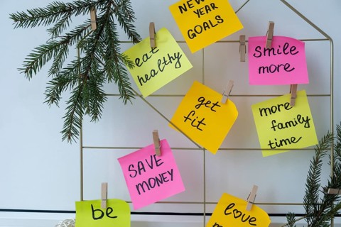 Vision board with new year resolutions aims goals on sticky notes. Preparation for New Year.