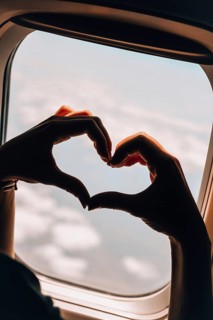 Female hand in heart shape Airplane flight. View from the window of the plane. Airplane, Aircraft.