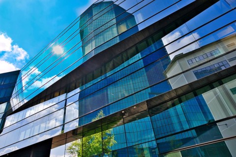 Modern glass façade of a high-rise building with reflections of sky and clouds, Prime Tower,