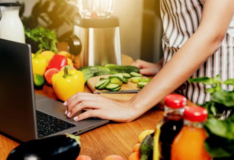 Young woman using laptop computer, girl hand clicking, touching pc. Person looking for recipe or