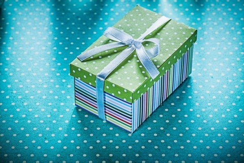 Wrapped gift on blue dotted tablecloth Holiday concept