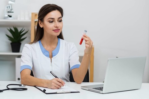 Smiling doctor looking blood sample
