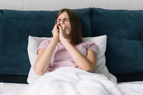 Pretty woman lying bed suffering from cold