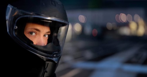 Young beautiful woman motorcyclist in a motorcycle helmet, road safety, motorcycle equipment