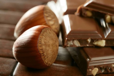 Hazelnuts and chocolate on brown wood enviroment at studio
