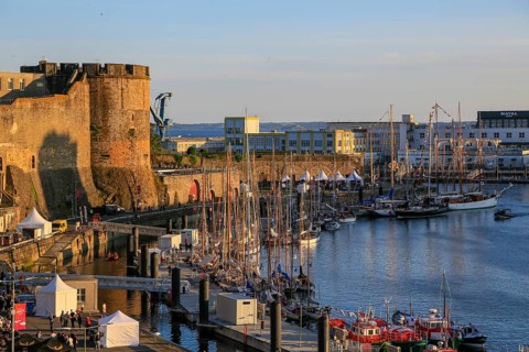 Sailing boats in front of the Chateau de Brest fortress at the mouth of the river Penfeld into the