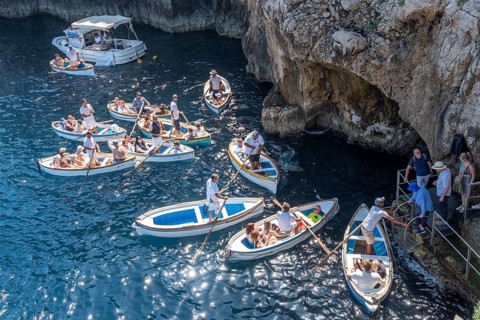 Italy, Gulf of Naples. Island of Capri, Blue Grotto. Boats with tourists in front of the entrance