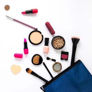 Different cosmetics scattered from beauty bag table