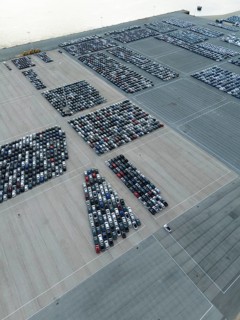 New Cars on Large Half Empty Parking Lot in Port Ready for Distribution. Harbor Car Storage for