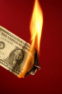 Dollar note, american currency burning in fire over red background, studio shot
