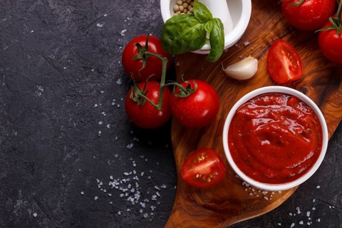 Tomato sauce with garlic, basil and spices in a white bowl closeup.horizontal top view