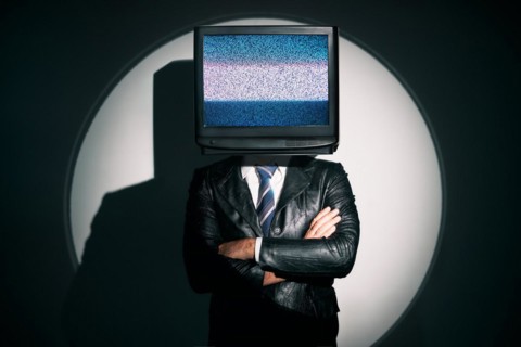 Man with TV instead of head. Media zombie concept with television addicted male in black coat with