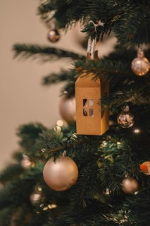 Christmas decorations on the Christmas tree, paper lantern in the shape of a house. Christmas warm