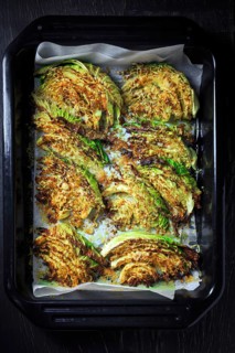 Baked savoy cabbage with parmesan cheese, honey and spices on baking sheet
