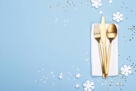 Christmas or new year table setting with golden cutlery on the blue background with copy space