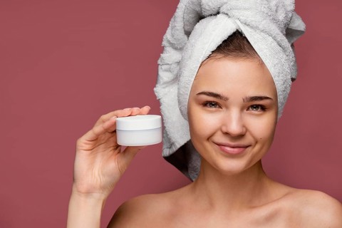 Beautiful woman using face cream
