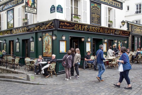 Paris, France, May 12, 2017: The streets of Montmartre district with people sitting in cafes and