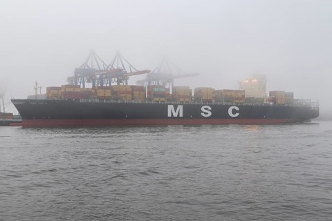 Weather, heavy fog in winter, container gantry cranes and container ship MSC Sola of the Swiss