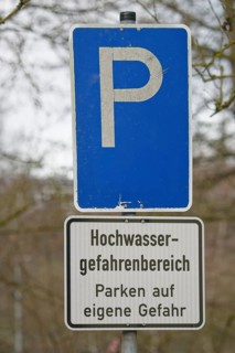 Flood-prone car park on river bank, flood, flood hazard area, information sign, parking sign,