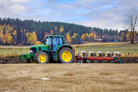 Farmer ploughing stubble field with John Deere 7530 tractor and plough on a day of autumn. Salo,