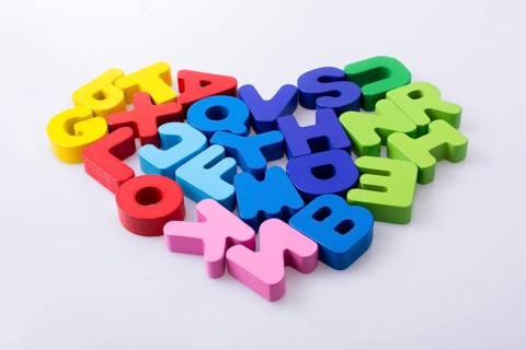 Colorful letter blocks shape heart on white background
