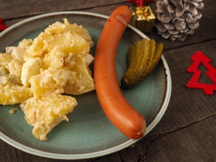 Tasty homemade potato salad with organic sausage and gherkin, traditional Christmas meal