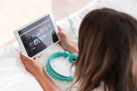 Young woman holding tablet with spotify app. High resolution photo