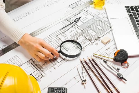 Person using magnifyer blueprint