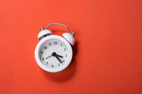 Alarm clock on colorful background in view