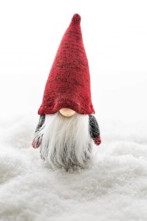 Traditional imp in the snow on white background. Christmas symbol