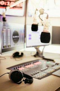Studio microphone in a broadcasting radio studio, mixer and computer in the blurry background