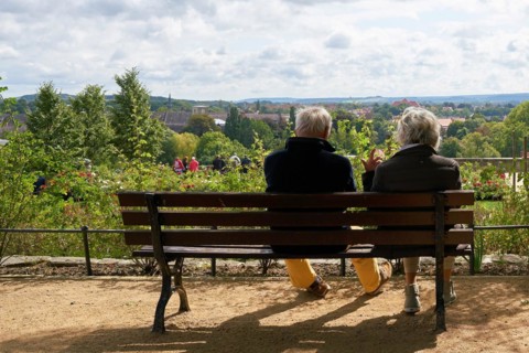 Elderly pensioner couple sitting on a bench and enjoying the view